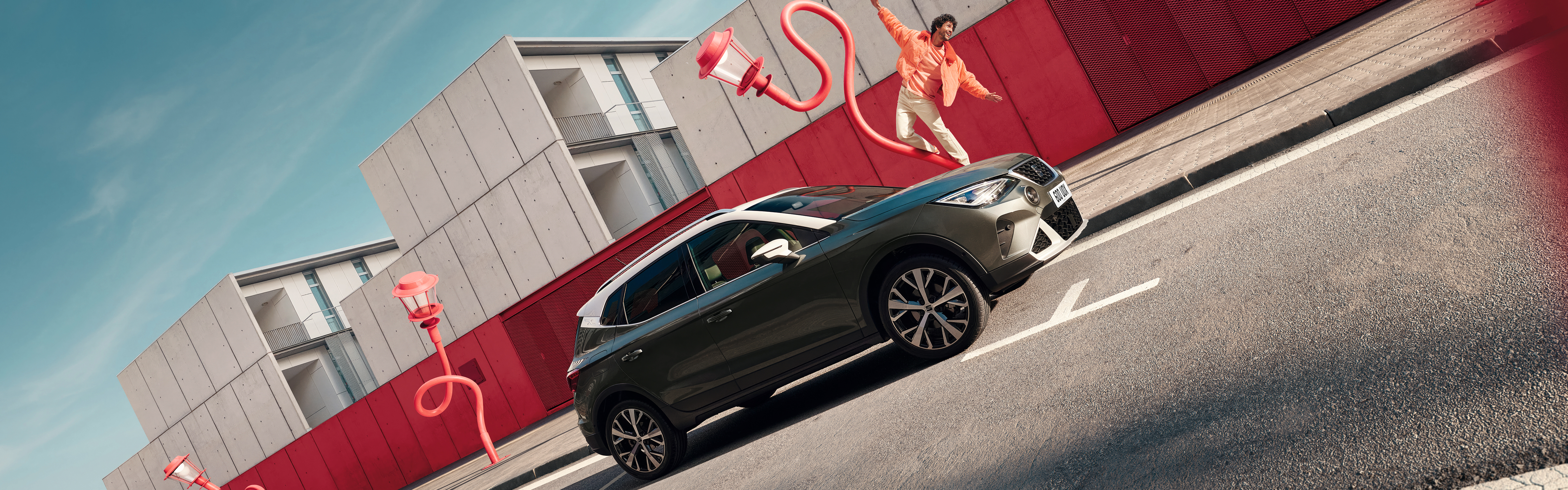 A man dancing on a lamp post next to a SEAT Arona