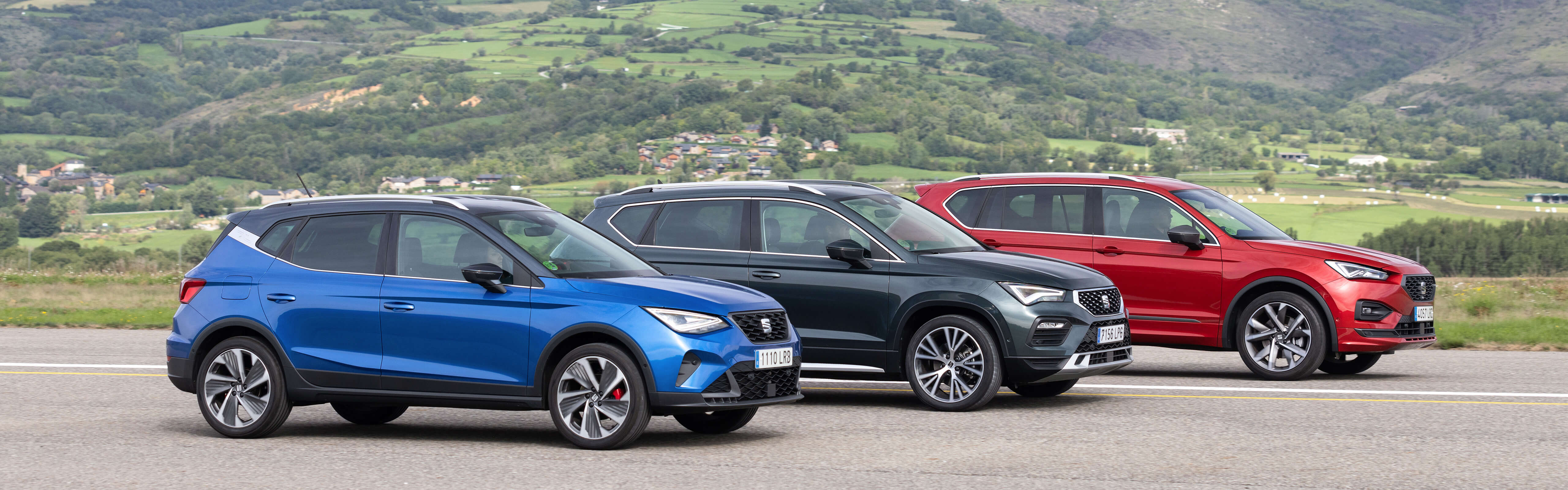 Three SEAT SUVs parked in front of a countryside view