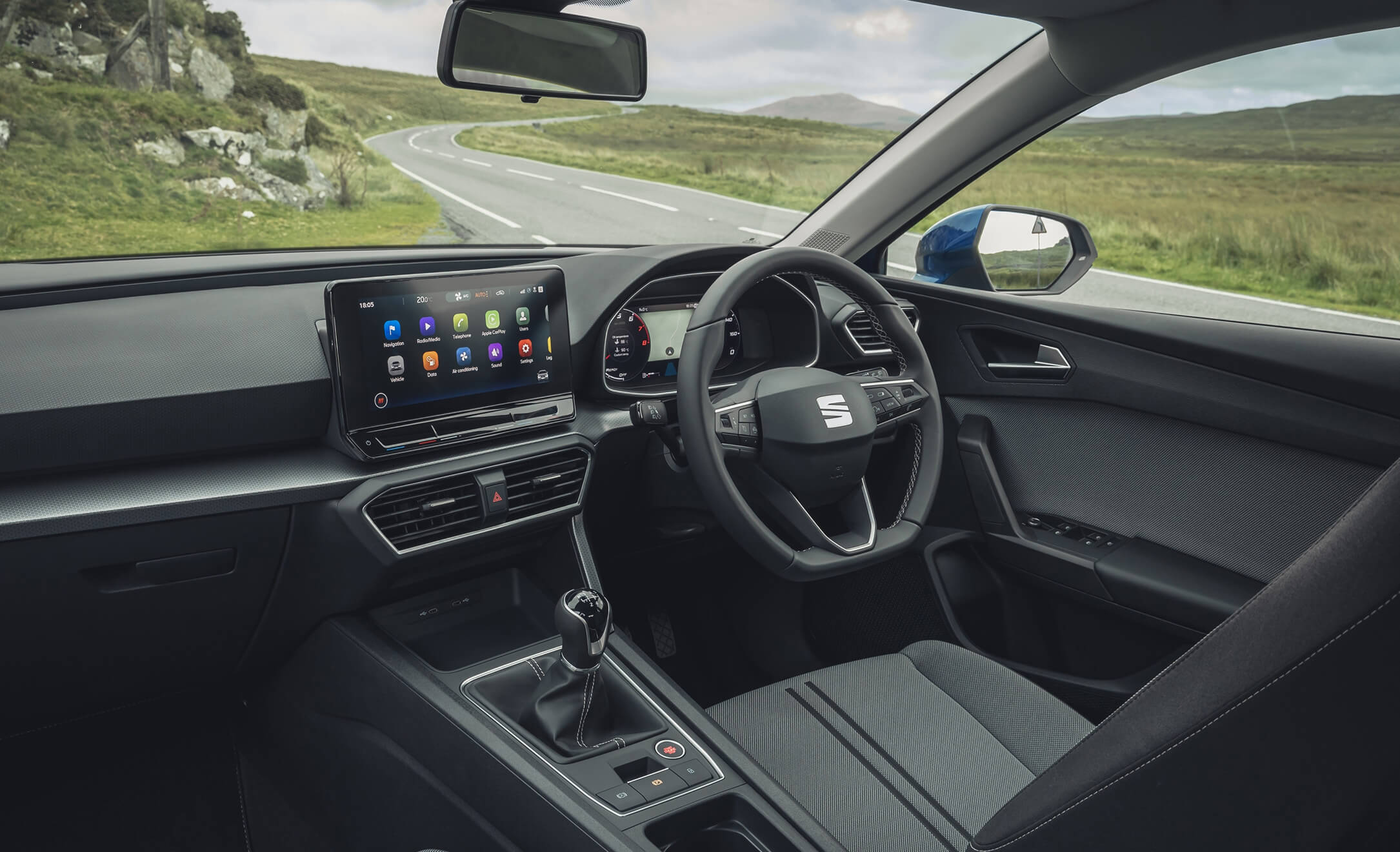 The interior view of a SEAT, including steering wheel and digital display.